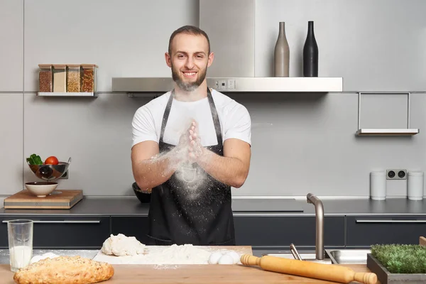 在现代厨房里 穿着厨师围裙的男人在揉搓面团袜子面包 — 图库照片#