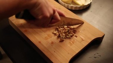 Kadın elleri ahşap tahtada ceviz keserken kapanır.