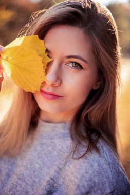 Sarı yapraklarla oynayan kadın 