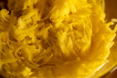 Cam kasede tahta kesme tahtasının üzerinde çiğ patates yakın plan. İsviçre patatesi ya da krep için ızgara ve dilimlenmiş patates yığını 