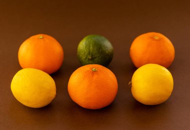 Taze turuncu ve sarı narenciye meyveleri siyah arka planda.