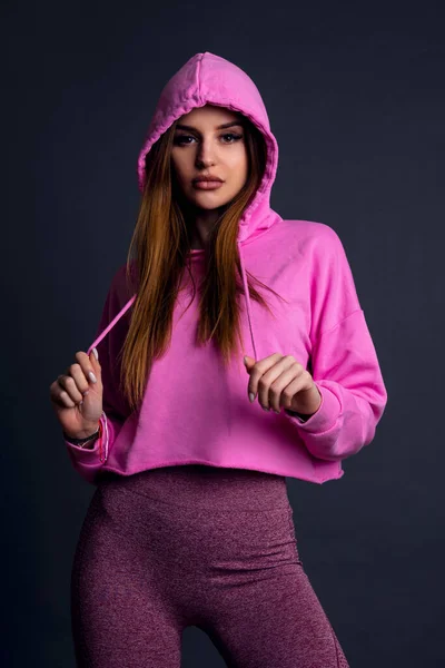 ピンクのパーカーとピンクのレギンスを着たスタジオの女性 — ストック写真