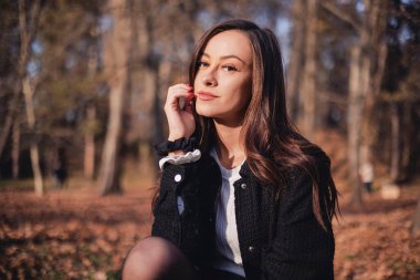 Güz parkında güzel genç bir kadın.