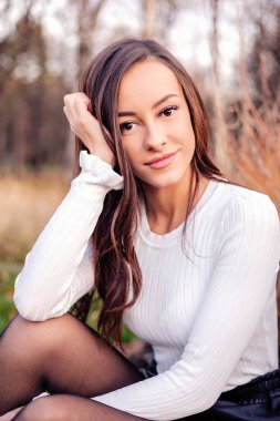 Güz parkında güzel genç bir kadın.