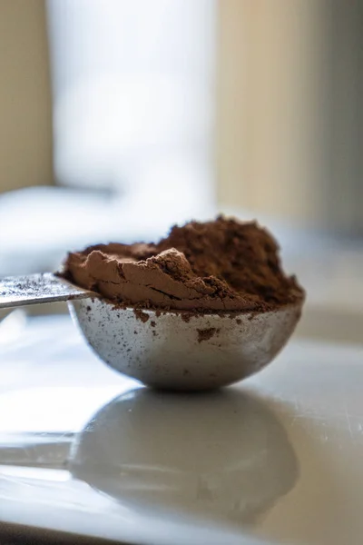 stock image metal spoon with cacao powder close up in white background