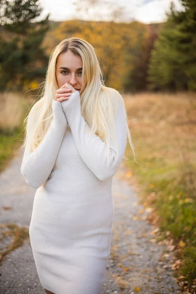 beautiful woman with white dress and black boots in a fall scene outdoor