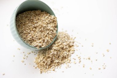 Küçük mavi bir kasede yulaflar beyaz arka planda izole edilir.