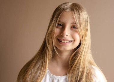 Beyaz elbiseli gülümseyen genç kızın portresi.