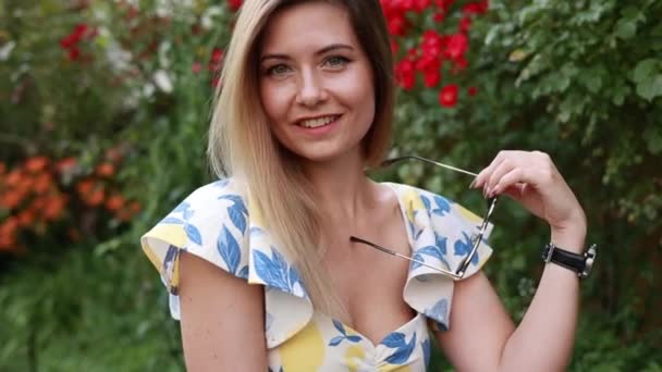 Blond Vrouw Dragen Zonnebril Met Een Moderne Outfit Een Tuin — Stockvideo