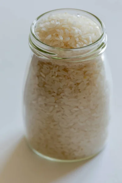 Surowy Biały Ryż Szklanym Słoiku Bliska Białym Tle — Zdjęcie stockowe