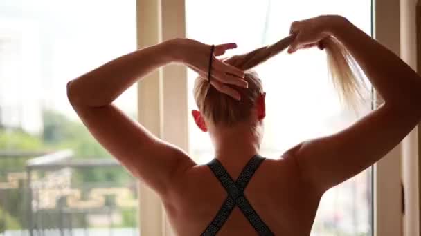 女人在家锻炼的过程中 她创造了一条马尾辫 展示了自己的健康和决心 — 图库视频影像