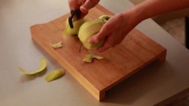 Mutfaktaki kadın elmalı pasta için elma soyuyor.