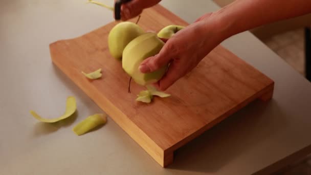 キッチンの女性はりんごケーキのリンゴを剥がします — ストック動画