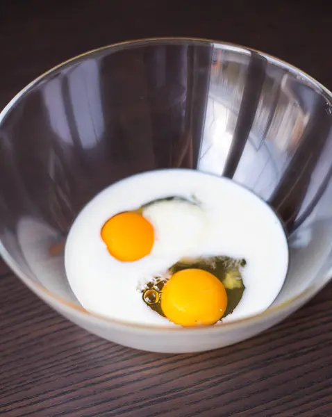 Close-Up of Eggs and Milk Ready to Mix in Glass Bowl