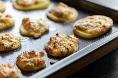 İştah açıcı mükemmellik tepsi parti yemeğinin içine doldurulmuş lezzetli patatesleri yakalamak.