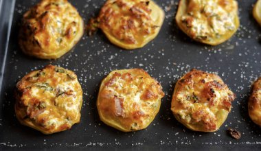 İştah açıcı mükemmellik tepsi parti yemeğinin içine doldurulmuş lezzetli patatesleri yakalamak.