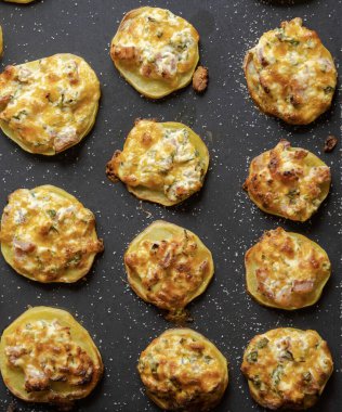 İştah açıcı mükemmellik tepsi parti yemeğinin içine doldurulmuş lezzetli patatesleri yakalamak.