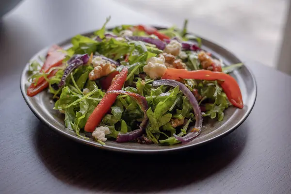 Winter Salad with Rucola, Red Onion, Canned Red Pepper, and Walnuts Close-Up