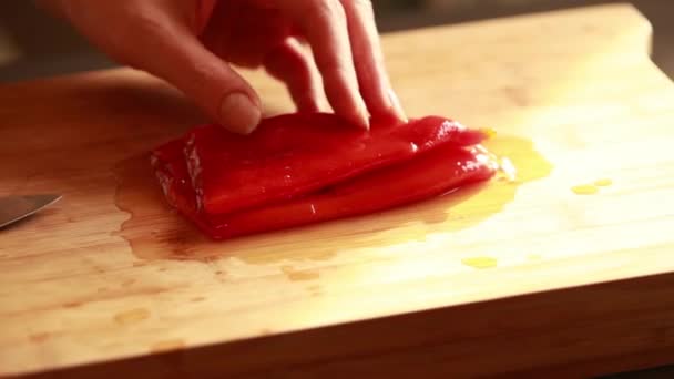 木版特写镜头上的妇女手工切碎罐装红辣椒 — 图库视频影像
