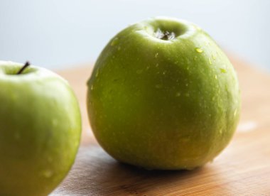 Tahta tahtada su damlaları olan taze organik yeşil elma gevrek ve sulu lezzet