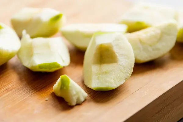 Fresh Organic Cut Green Apple Close Up on Wooden Board - Crisp and Wholesome Slice