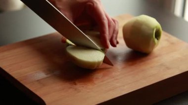 Kadın elleri elmaları kesiyor. Yakın mesafeden kesiyor. Yaşam tarzında yemek pişiriyor.