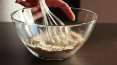 Cam bir kasede pişirmek için kuru malzemeler karıştırıyorum.