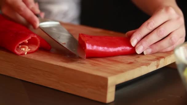 烹调技巧 女性手在木板上切鲜红椒特写 — 图库视频影像