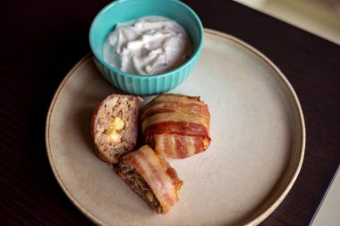 Lezzetli yemek: domuz pastırmasına sarılmış köfteli leziz yemekler, mozarella ve yoğurt sosuyla dolu.