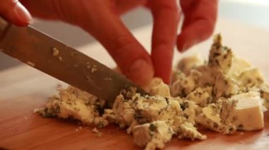  Kadın elleri kesiyor, ahşap tahtada mavi peynir kesiyor.