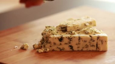  Kadın elleri kesiyor, ahşap tahtada mavi peynir kesiyor.