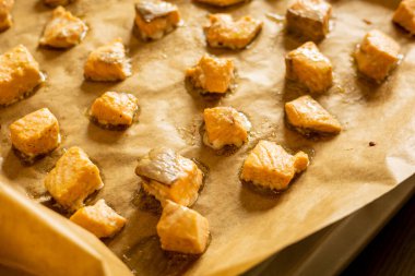 Parşömen kağıdında pişmiş somon küpleri.