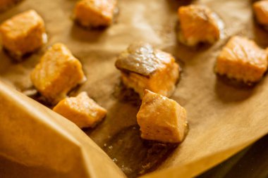 Parşömen kağıdında pişmiş somon küpleri.