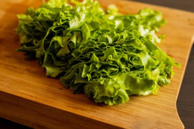  Tahta kesme tahtasına yeni kesilmiş marul yakın plan.