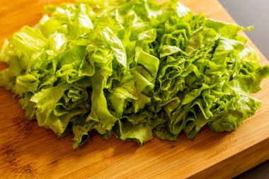  Tahta kesme tahtasına yeni kesilmiş marul yakın plan.