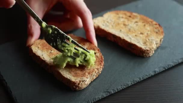 Bir Dilim Ekmeğin Üzerine Kremalı Avokado Döken Birinin Büyüleyici Yakın — Stok video