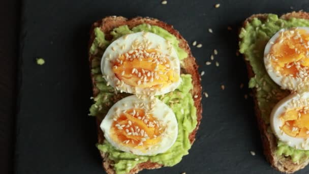地中海のアボカドトーストと沸騰した卵とゴマ — ストック動画