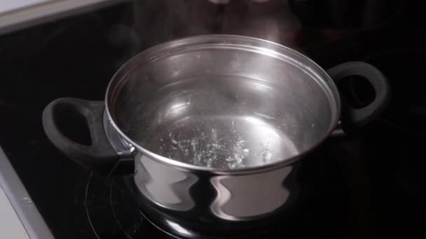 ストーブの上の鍋に沸騰する水のプロセスをキャプチャするクローズアップストックビデオ 泡立ちと蒸気を強調 — ストック動画