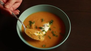  Mavi bir kasede sunulan havuç çorbası ev yapımı yemeğin rahatlığını ve sıcaklığını gösteriyor..