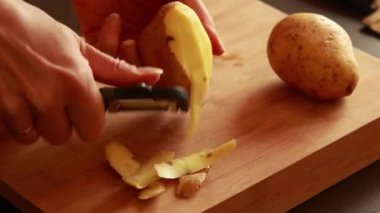  Kadın elleri tahta tahtada patates soyuyordu.