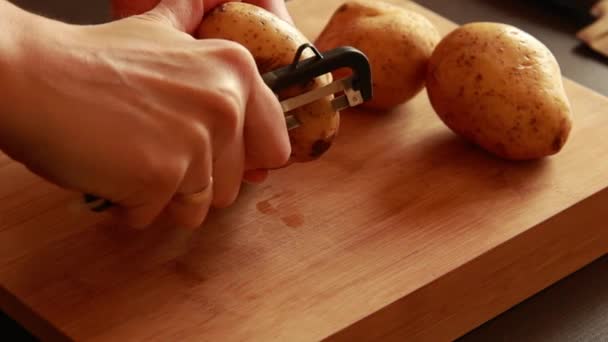 女人的手在木板上削土豆 — 图库视频影像