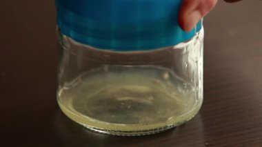 İnsan eli bu büyüleyici yakın çekimde limon suyunu sıkmak için manuel meyve sıkacağı kullanır. 