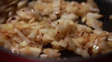 Ahşap kaşık soğanları bir tavada nazikçe karıştırırken yavaş yavaş iştah açıcı bir altın hamura dönüşüyorlar. Meçhul şef bu yakın çekim stok videosundaki aşçılık sürecini ustalıkla yönetiyor.