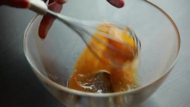  Bu 4K yakın çekim videosunda krep hazırlamak için çırpılmış yumurta çırpılmış.