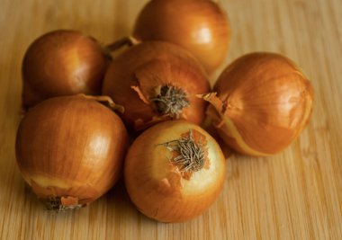 Tahta doğrama tahtasında bir sürü altın soğan.