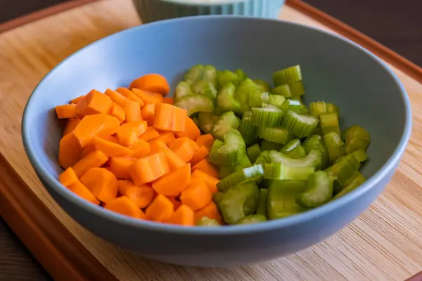 stock image  Chopped Carrots and Celery in a Blue Bowl for Soup Base Preparation Close-Up