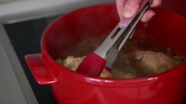 Haşlanmış tavuk göğsünü yakın plan kırmızı saksıdan çıkarıyorum.