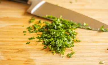 Kesme tahtasında doğranmış maydanoz.