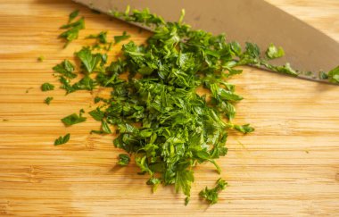 Kesme tahtasında doğranmış maydanoz.