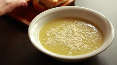 Parmesanlı kabak kremalı çorba ve koyu arkaplanda sarımsaklı ekmek.